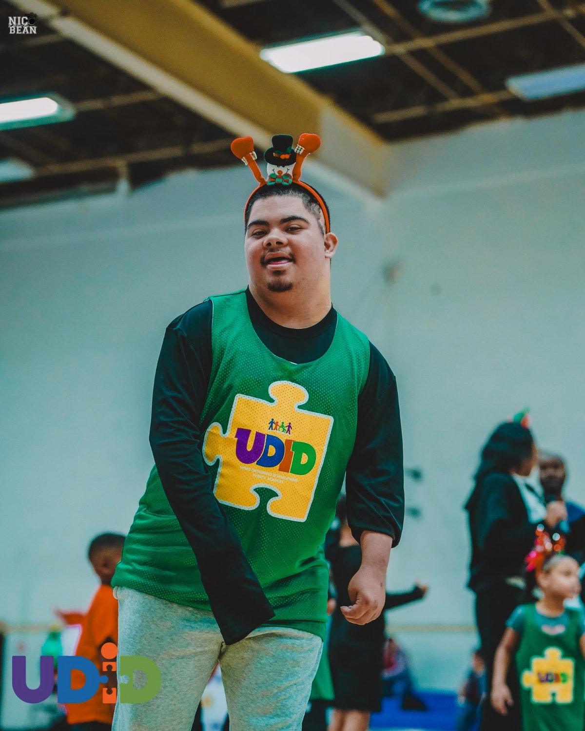 Coach guiding youth player in UDID Academy basketball drill